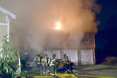 Firefighters battle a blaze early Friday morning at a Kent duplex in the 900 block of Fourth Avenue North.