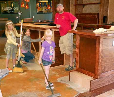 Restaurateur Mick Purdy gets help from his three daughters July 20 at the new restaurant he and his cousin Adrian Kelly will be opening this month at the Riverbend Golf Course in Kent. The restaurant is Mick Kelly’s. The cousins have been operating a Mick Kelly’s out of Burien already