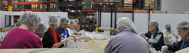 Volunteers help package food at the Northwest Harvest warehouse in Kent.