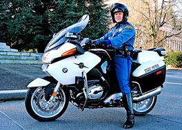 A trooper poses on a Washington State Patrol motorcycle.