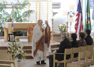 Father Michael J. Ryan presides over the sevices Thursday for Kent City Councilman Bob O’Brien at Holy Spirit Church in Kent. The event brought residents from across the region who had known O’Brien