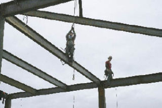 Construction workers on Jan. 9 prepare to install beams at the Kent Events Center. A labor dispute last week resulted in workers walking off the job. Construction has since resumed