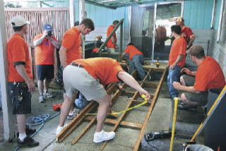 Nearly 20 employees of Bellevue-based Kitchen Plus work May 17 to build and install a wheelchair ramp at the Kent home of Alfred Walker. Kitchen Plus donated the effort as part of the Master Builders Association’s annual Rampathon.