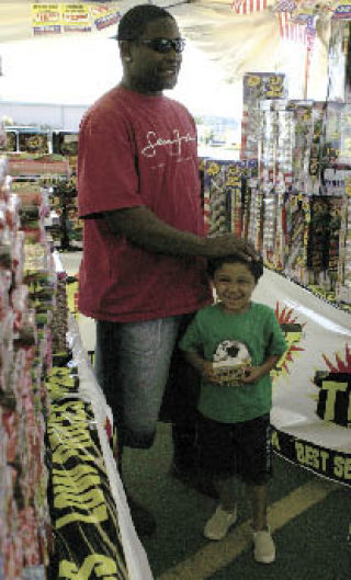 Marcel Jones Sr. and Marcel Jones Jr.  pick out fireworks last year from a booth in Kent selling the legal variety of July 4 devices. Local officials are asking residents to be cautious in using fireworks