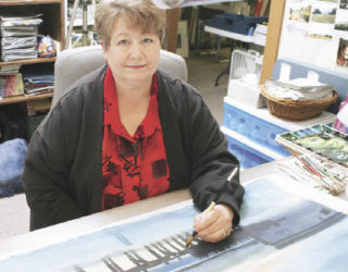 Ann Breckon works on a large-scale watercolor scene in her private studio in Kent July 23. Breckon is a featured artist in the “Paint Out Loud” Women Painters of Washington exhibit