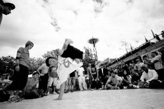 A breakdancer shows off his moves in the Seattle Center during last year’s Bumbershoot music and arts festival. The event – which features live music