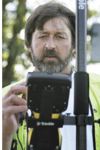 City of Kent surveyor Terry Johnson calibrates his instrument while surveying off Clark Lake Park Sept. 3.