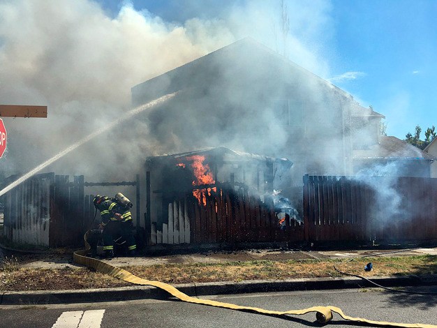 Firefighters take on a fire Monday afternoon at a house near 132nd Avenue Southeast and Southeast 266th Place.