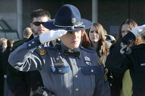 Officer C.L. Stewart of the Washington State Patrol salutes Dec. 8 as the flag-draped caskets of four Lakewood Police officers are carried into the Tacoma Dome for a memorial service. Nearly 20