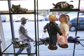 Bernard Maina of Kent passes by a display of dolls and die-cast collectible cars at Treasures