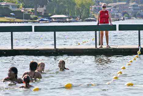 Lifeguard Alicia Flatt stands on the dock at Kent's Lake Meridian Park July 21 as she continuously scans to make sure patrons are following the rules and staying safe.