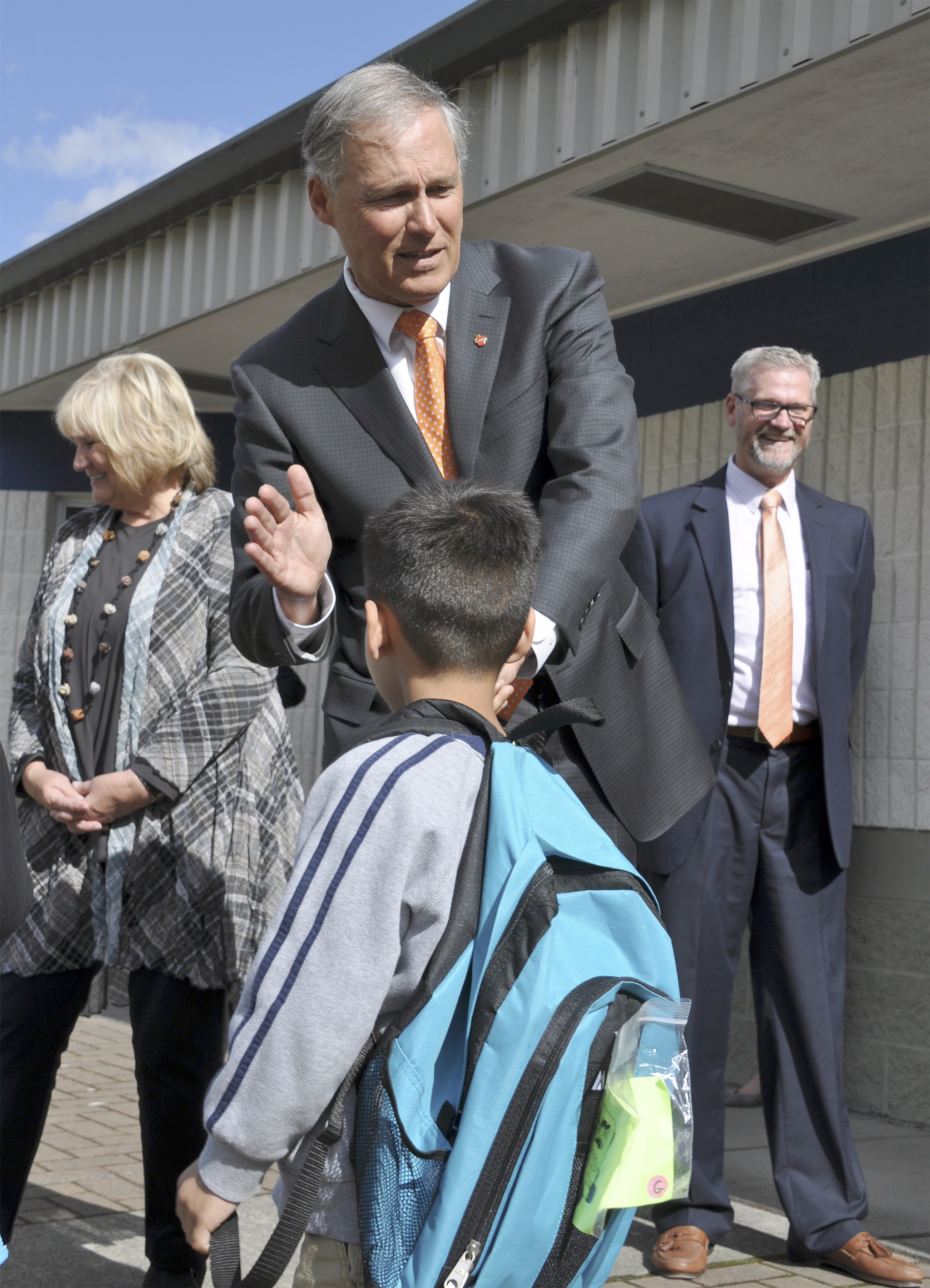 Gov. Jay Inslee gives a high-five to a kindergartner during a visit to Kent’ Millennium Elementary School on Sept. 8. Heidi Sanders