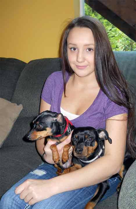 Jane Johnson sits with her two miniature pinschers at home in Kent June 18. Johnson has Severe Chronic Neutropenia Kostmann’s Syndrome