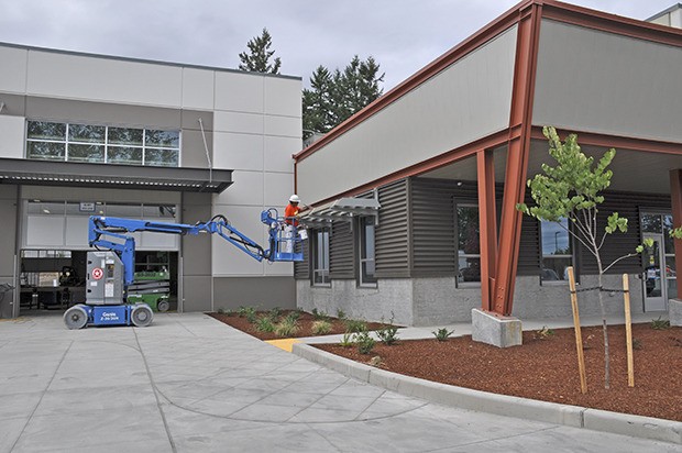 A worker applies finishing touches to the exterior of the Green River College Trades Technologies building this week. The facility is expected to be ready  for the start of fall classes.