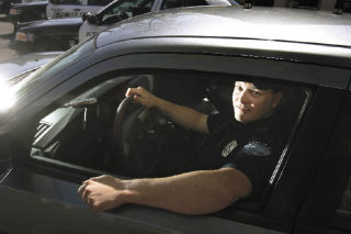 Kent Police officer Jeff Williams sits in the department’s unmarked Dodge Charger patrol car