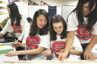 Wearing North Carolina State T-shirts sent to their class by the university