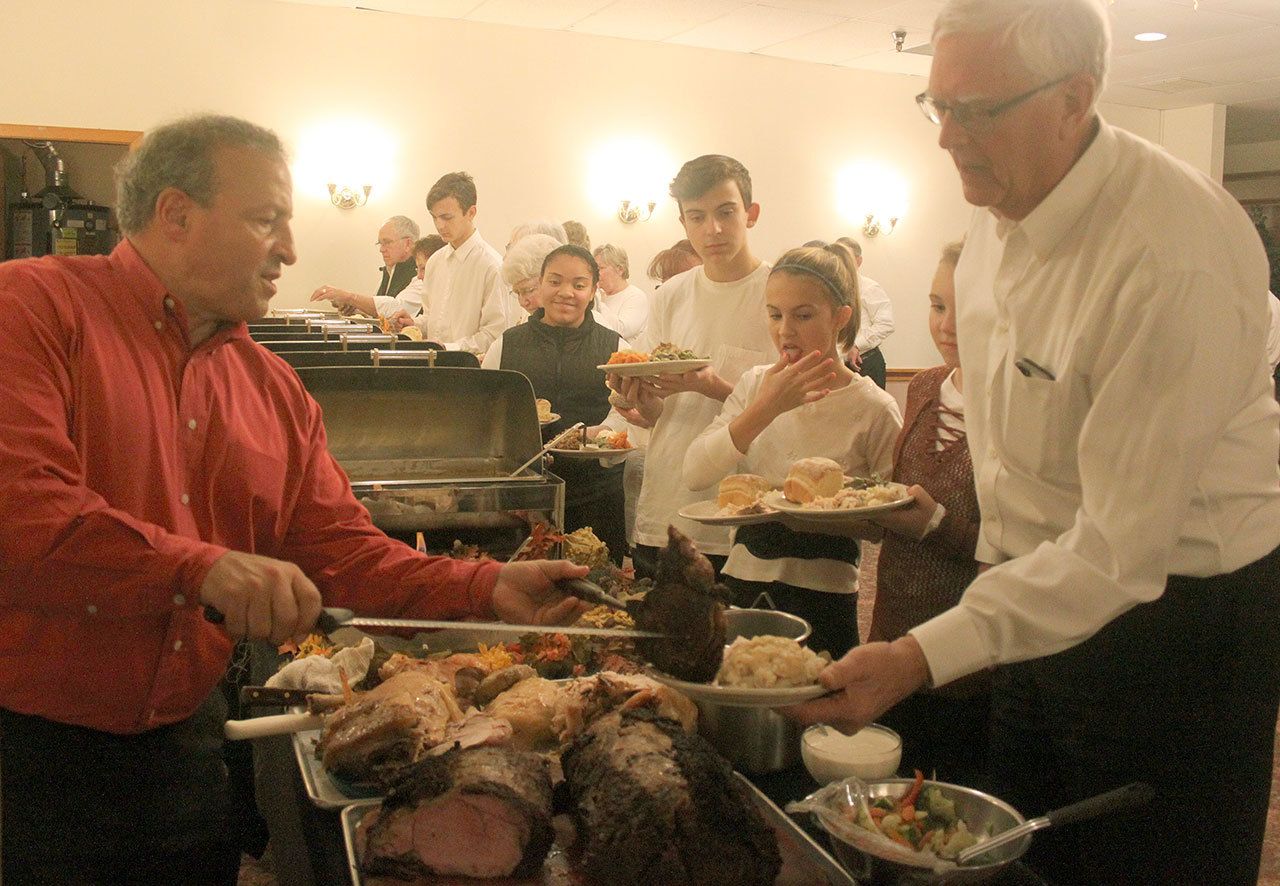 Jim Berrios, owner of the Golden Steer Steak ‘n Rib House, serves up Thanksgiving meals to volunteers at the restaurant’s annual community dinner on Nov. 24. Volunteers then went to work, serving 443 people who came for dinner. BRIAN BECKLEY, Reporter