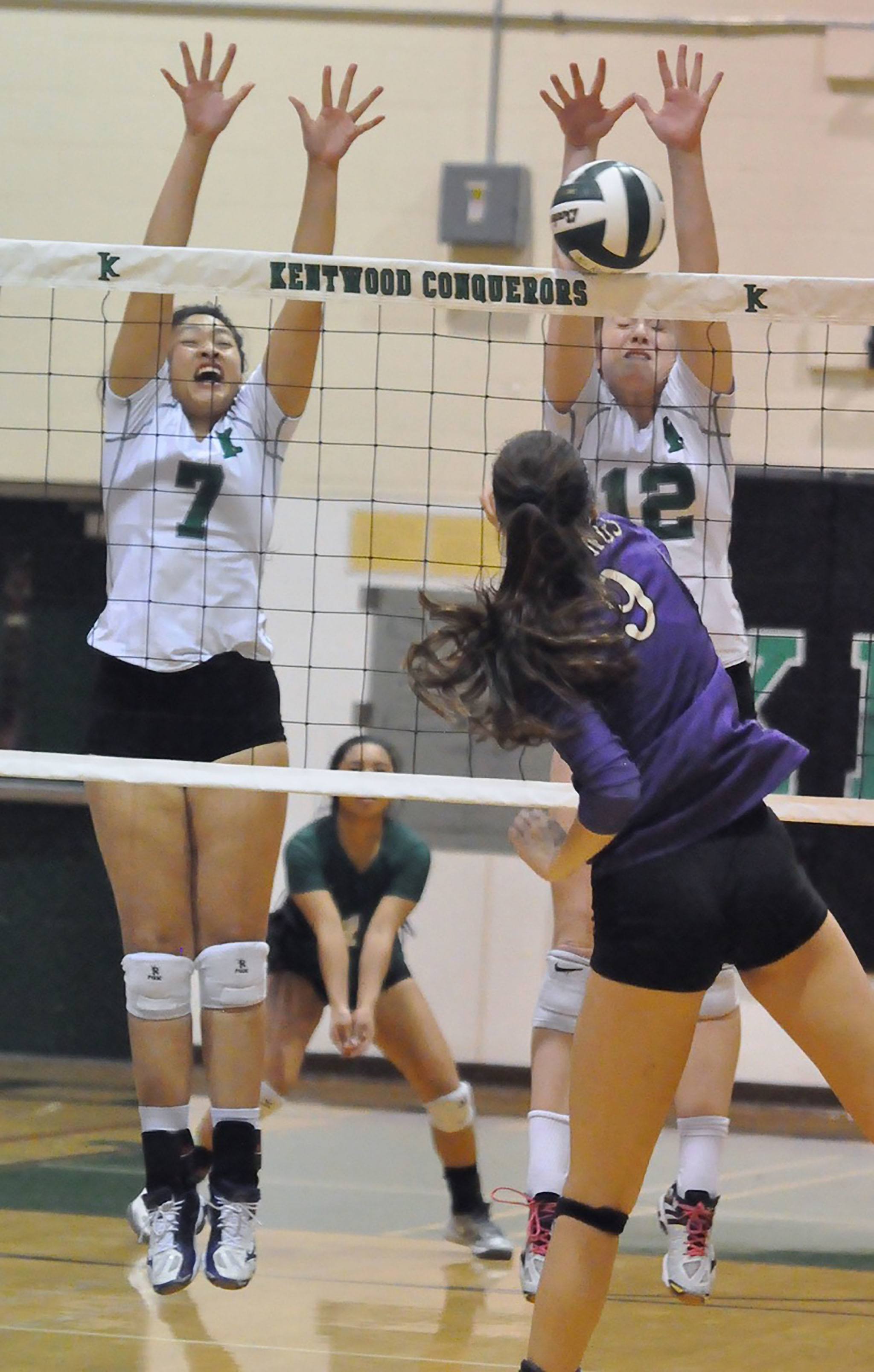 Kentwood’s Alvina Ngo, left, and Erin Gould attempt to block a shot by Puyallup’s Kaitlin Sugai during district action Saturday in the Conquerors gym. RACHEL CIAMPI, Reporter