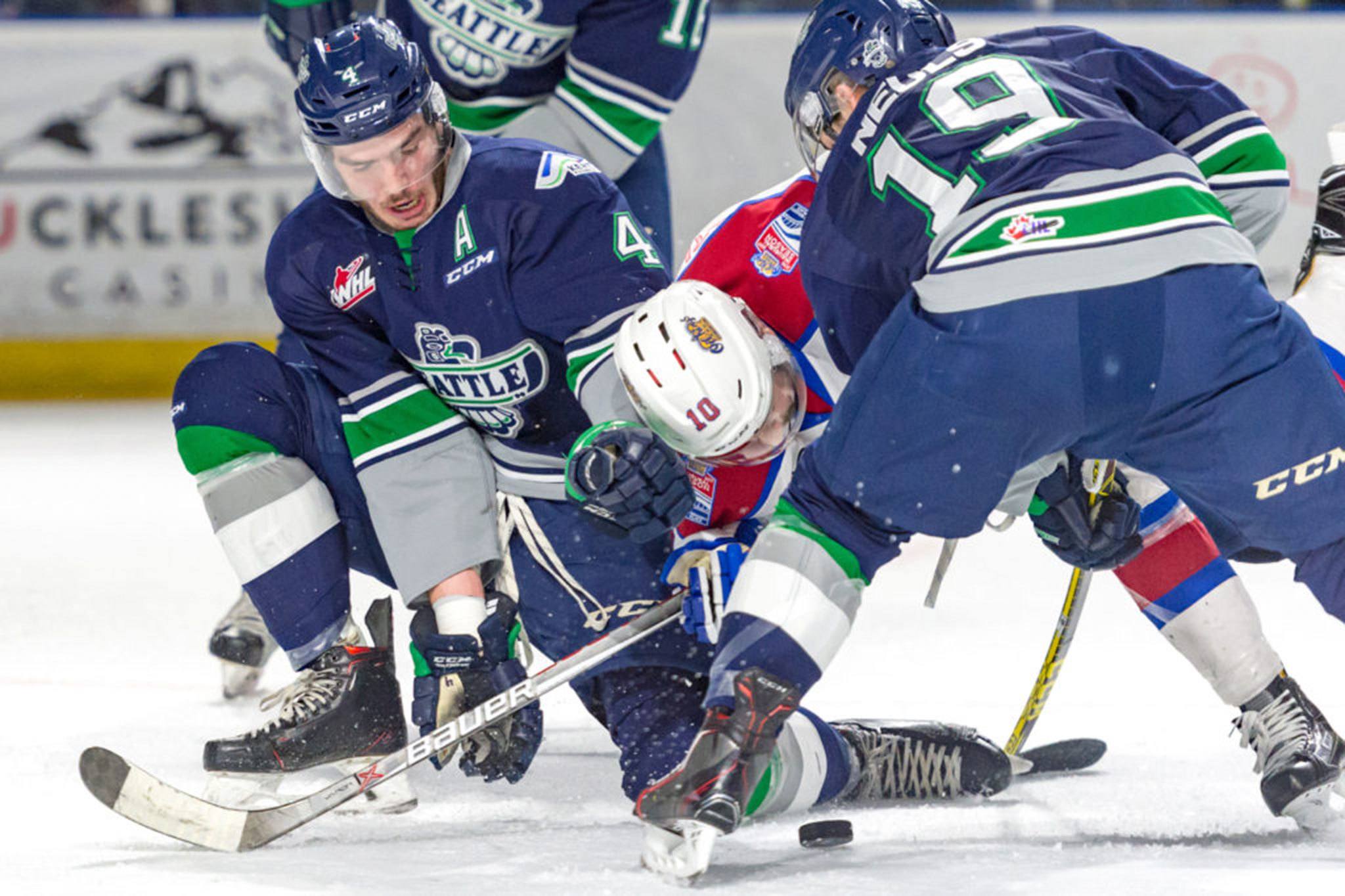 The Thunderbirds’ Turner Ottenbreit, left, and Donovan Neuls sandwich the Oilers’ Tyson Gruninger in a scramble for the puck Tuesday night at the ShoWare Center. COURTESY PHOTO, Brian Liesse, T-Birds