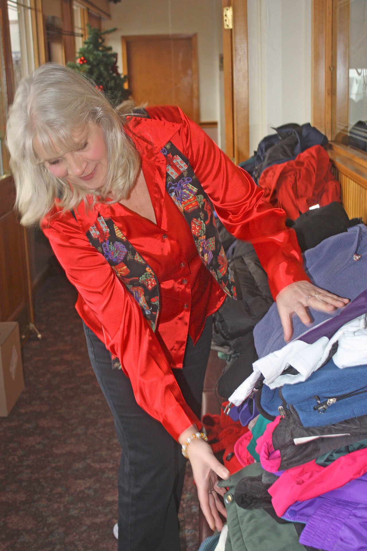 Cheryl Anderson, Willow’s Place board member, arranges donated jackets and coats during the Willow’s Place Hope for Families event on Thursday. MARK KLAAS, Kent Reporter