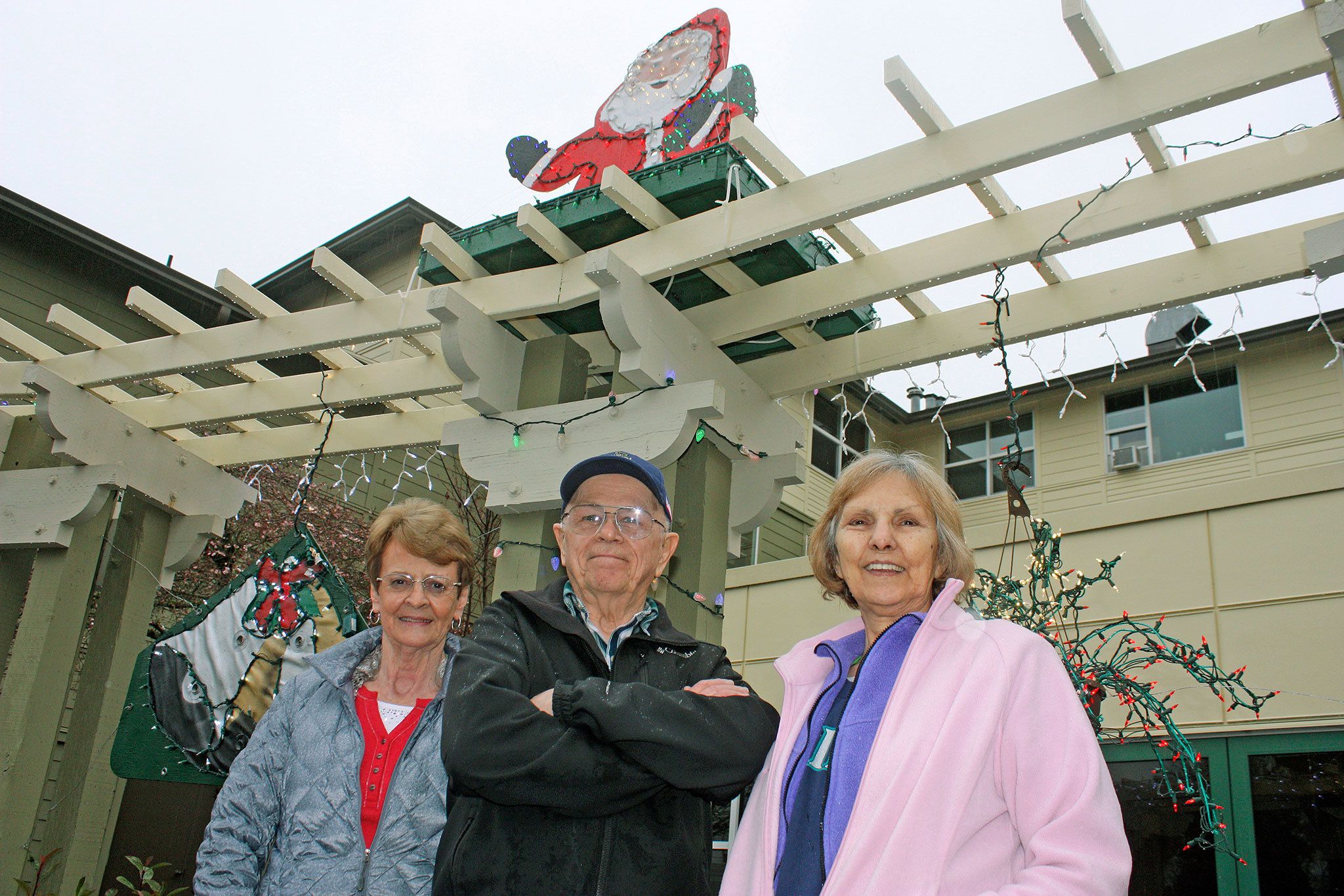 Harrison House tenants Dail Washburn, left, Bill Long, middle, Lynn Hamilton, right, and Blair Olson, not pictured, led the holiday decoration and lighting effort. MARK KLAAS, Kent Reporter
