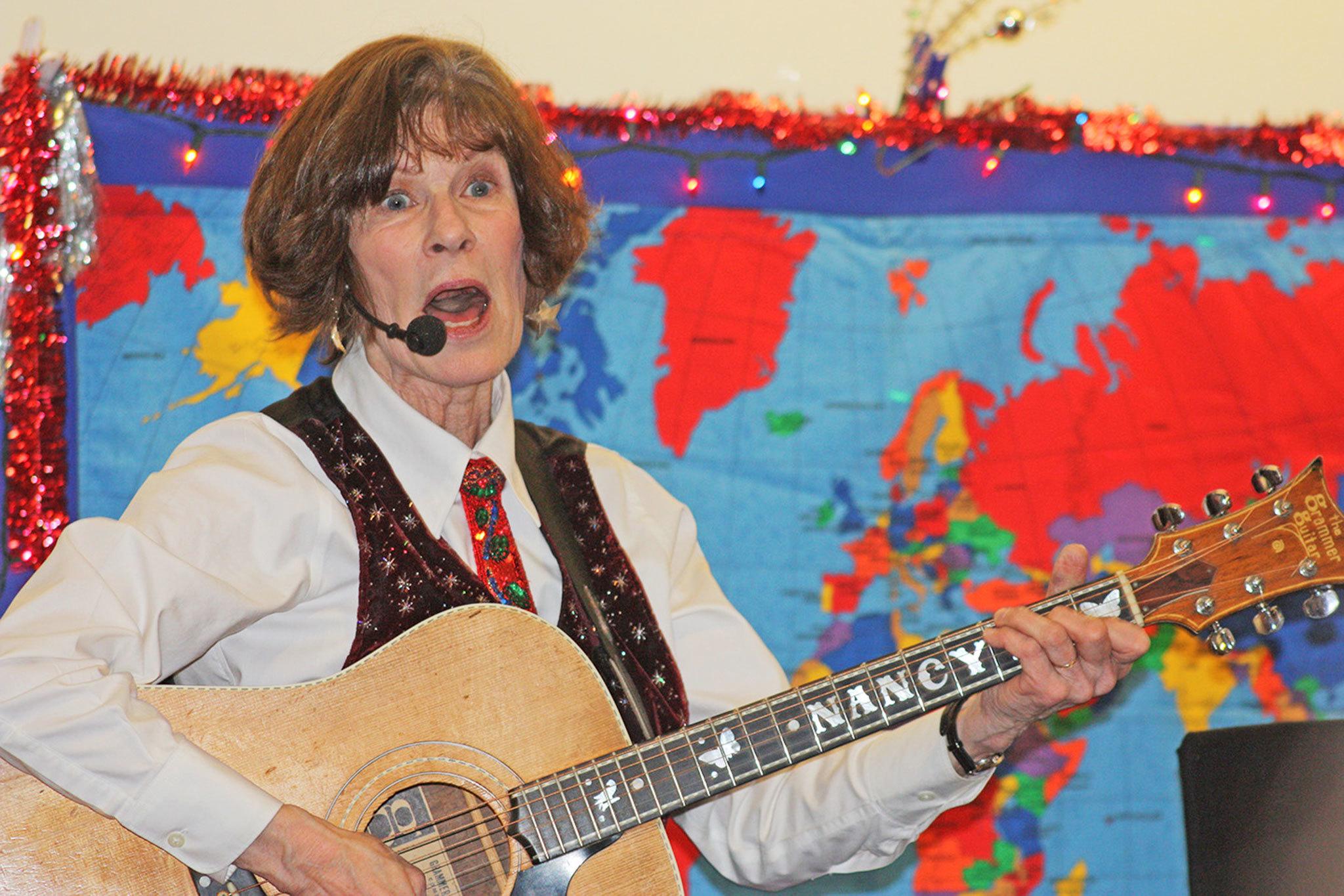 Nancy Stewart strums a number for her young audience. MARK KLAAS, Kent Reporter