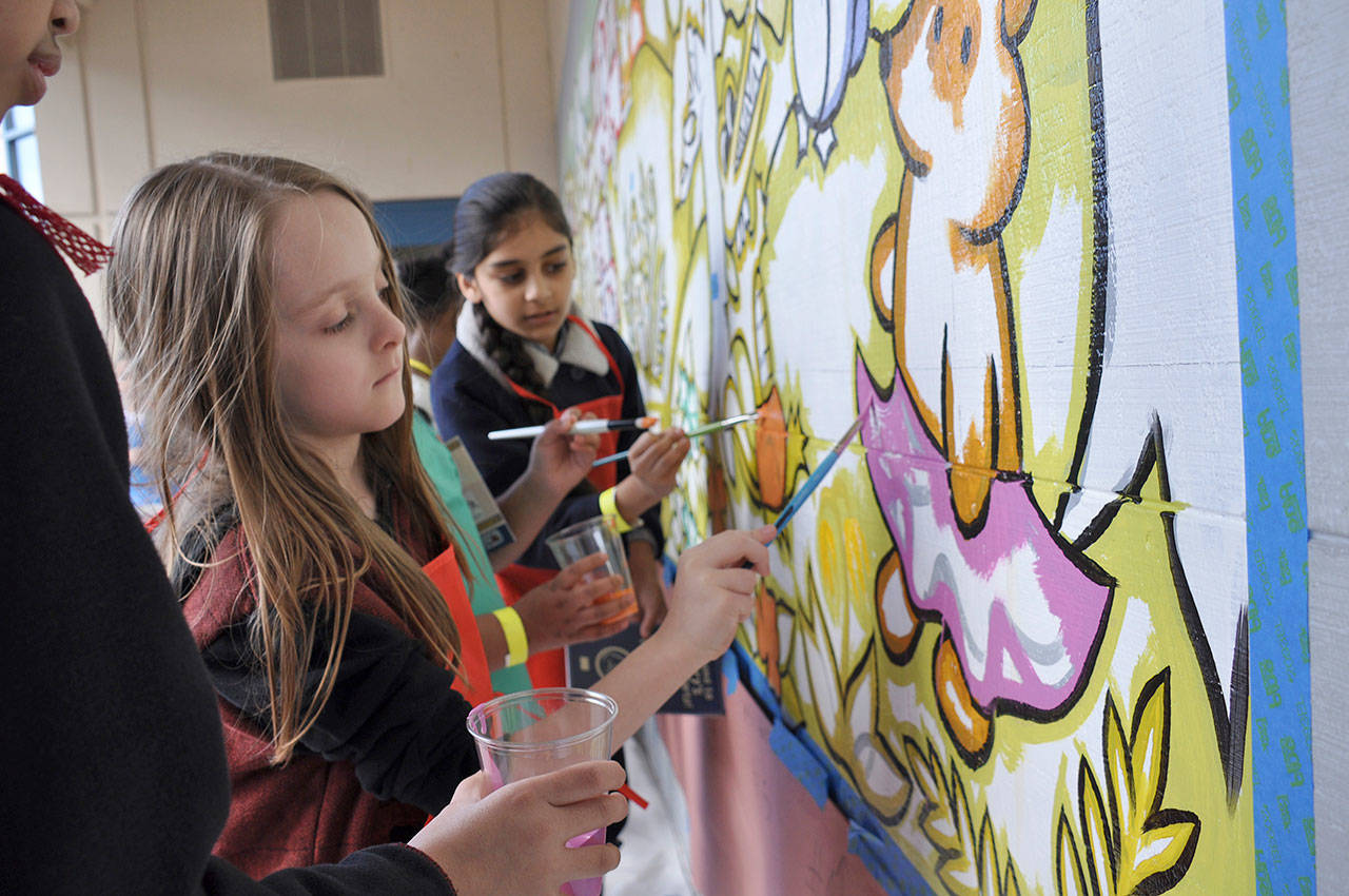 First-grader Caden Smith, left, and third-grader Avneet Singh paint a mural during a birthday party for Emery the Emergency Penguin, the mascot for the county’s E-911 program, at Kent’s Daniel Elementary School last Friday. HEIDI SANDERS, Kent Reporter