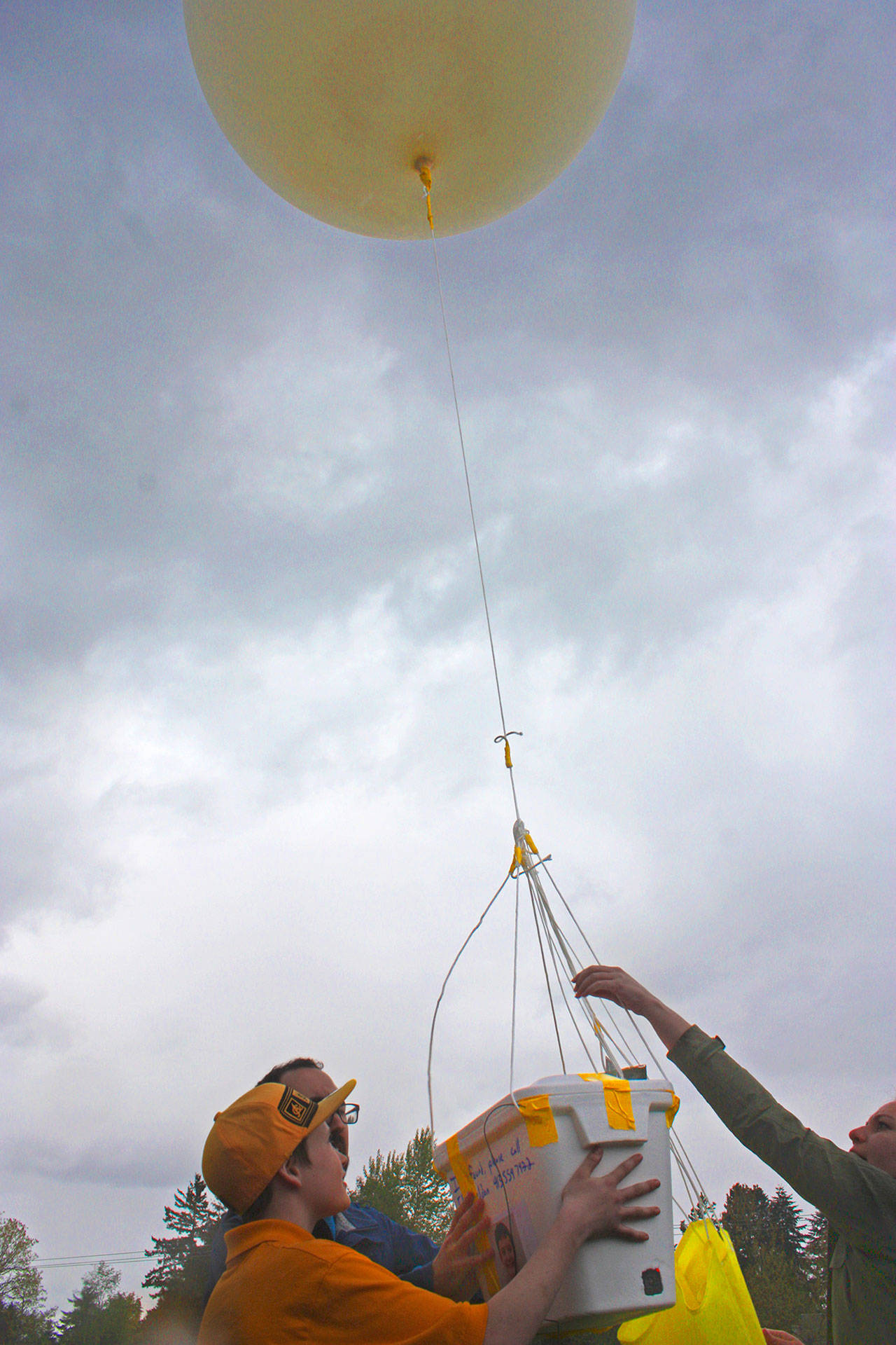 Ryelee Patten, an eighth-grader at the school, joins Eli Sheldon, the school’s Computational Thinking program manager, and volunteer Chrissie Grover-Roybal to release the weather balloon earlier Tuesday. MARK KLAAS, Kent Reporter