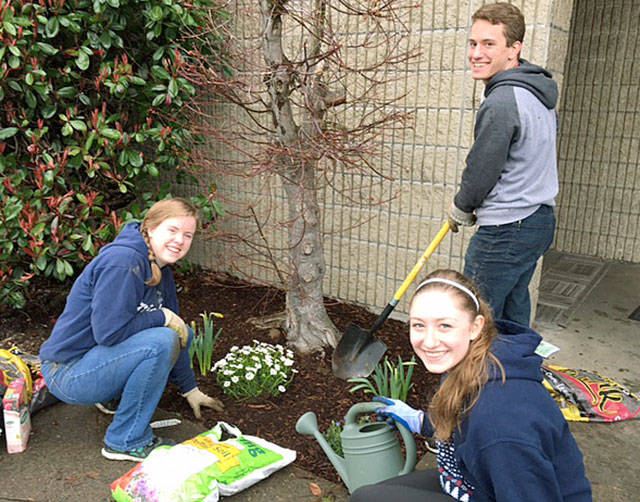 Kelly Tolonen, Belen Elliot and Silas Tuthill, from left to right, plant flowers donated by Kent East Hill Nursery and McLendon’s Hardware on April 1 at the Kent Post Office on the East Hill.