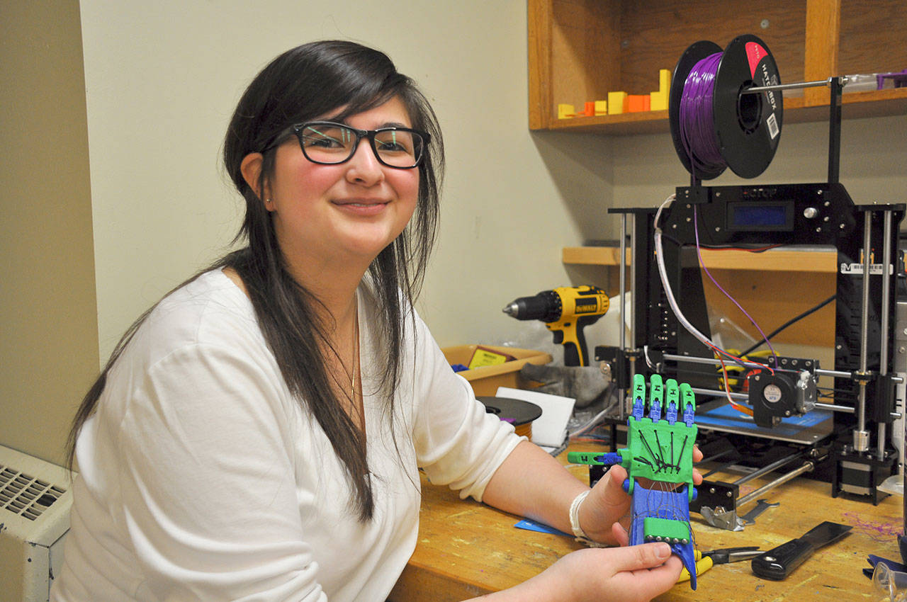 Kaiya Neuss, a student in the mechatronics program at Kent Phoenix Academy, displays a prosthetic hand she built made from parts printed on a 3-D printer she assembled. HEIDI SANDERS, Kent Reporter