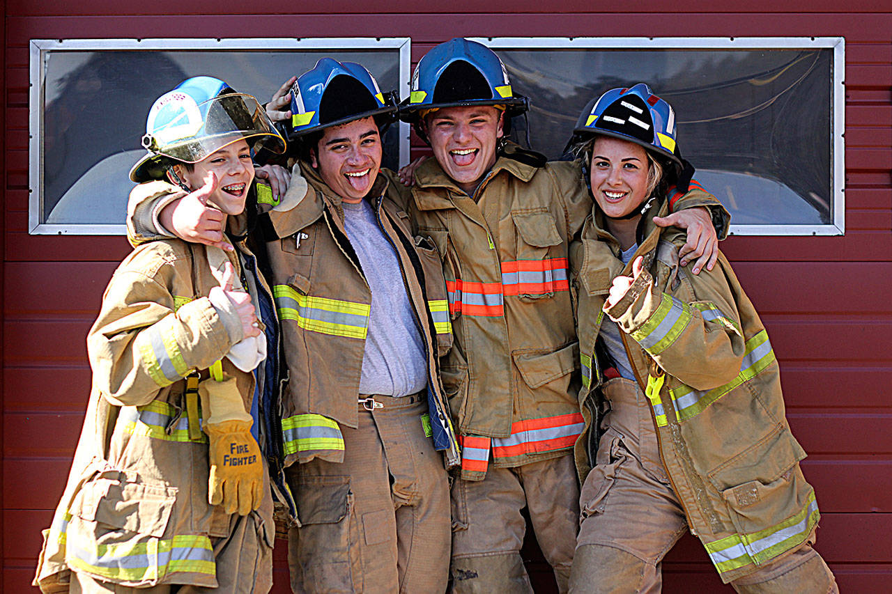 John Whitmore, left, Diego Santiago, Justin Thompson and Tyanna Cole of Zone 3 Explorers strike a pose at Maple Valley Fire Station 81. LEAH ABRAHAM, The Reporter