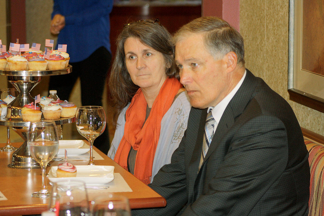 Gov. Jay Inslee discusses ways to increase funding to combat homelessness with Manuela Ginnett, Multi-Service Center housing director, left, and others during a visit Tuesday to the Radcliffe Place senior living affordable housing complex in Kent.