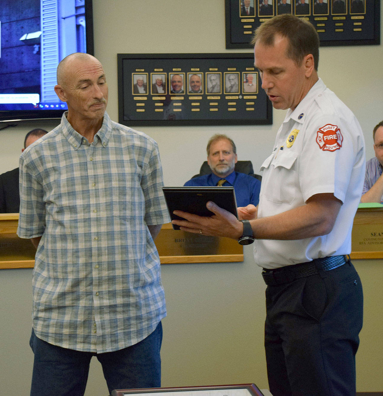 Puget Sound Fire Battalion Chief Tim Martinsen presents a lifesaving award to Jack Scheel on Wednesday at Fire Station 78 in Covington. Courtesy Photo/Puget Sound Fire