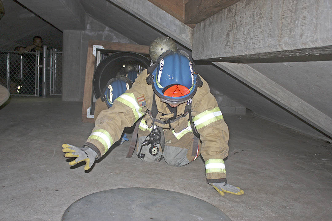 Cadet Kehaulani Planesi, A Company leader, leads her team on a search-and-rescue mission in a damaged, abandoned building on the Puget Sound Regional Fire Authority’s training center during a fire school for teens last week. MARK KLAAS, Kent Reporter
