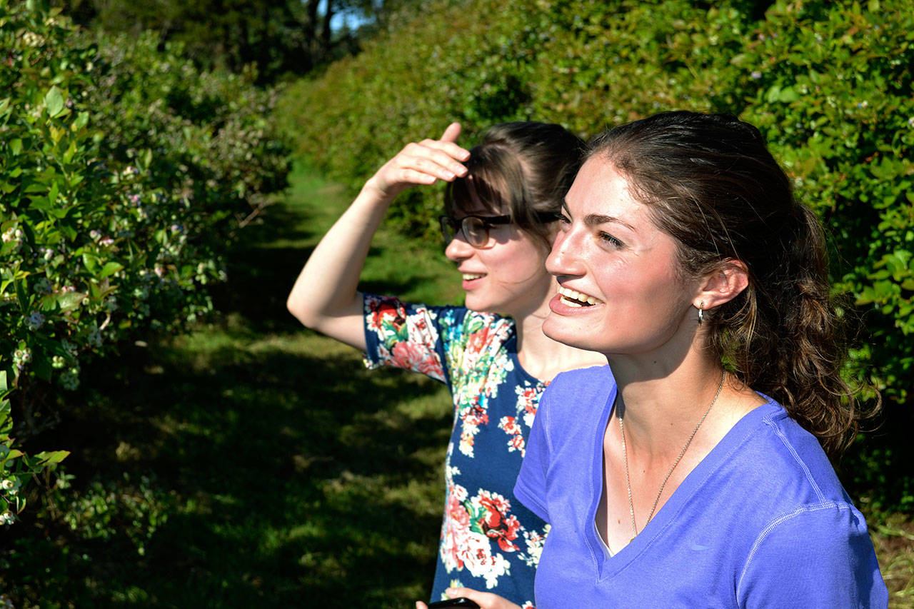 Making a difference: Esther “Estee” Byram, right, and her sister, Tiffany, glance at the work their family and volunteers have done to maintain an Auburn blueberry farm. ROBERT WHALE, Auburn Reporter