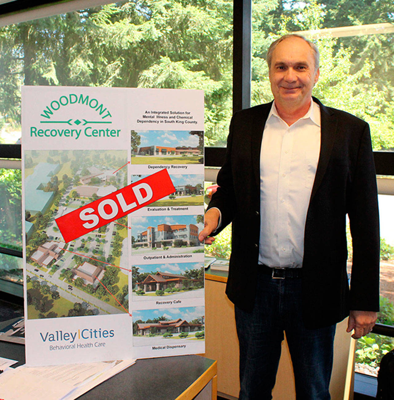 Valley Cities CEO Ken Taylor displays a ‘sold’ sign for the property that was to house the Woodmont Recovery Center. RAECHEL DAWSON, Federal Way Mirror