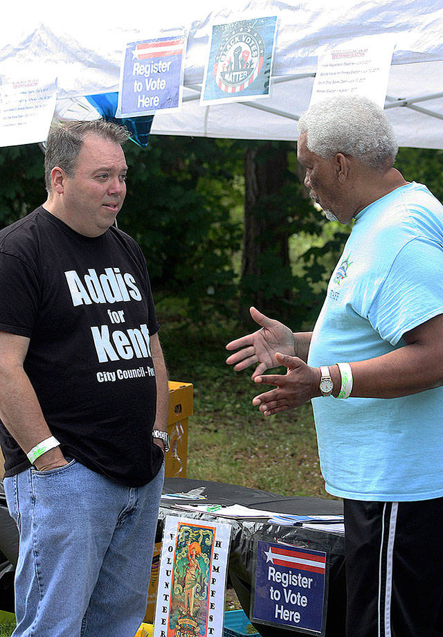 Paul Addis, a Kent City Council candidate, talks to Juan Vega, director of voter registration for KBAC (Kent Black Action Commission) and Hempfest, during the Juneteenth festival on June 17 at Morrill Meadows Park. Vega has participated in the event for each of its six years. KBAC had a voter registration booth at the celebration. MARK KLAAS, Kent Reporter