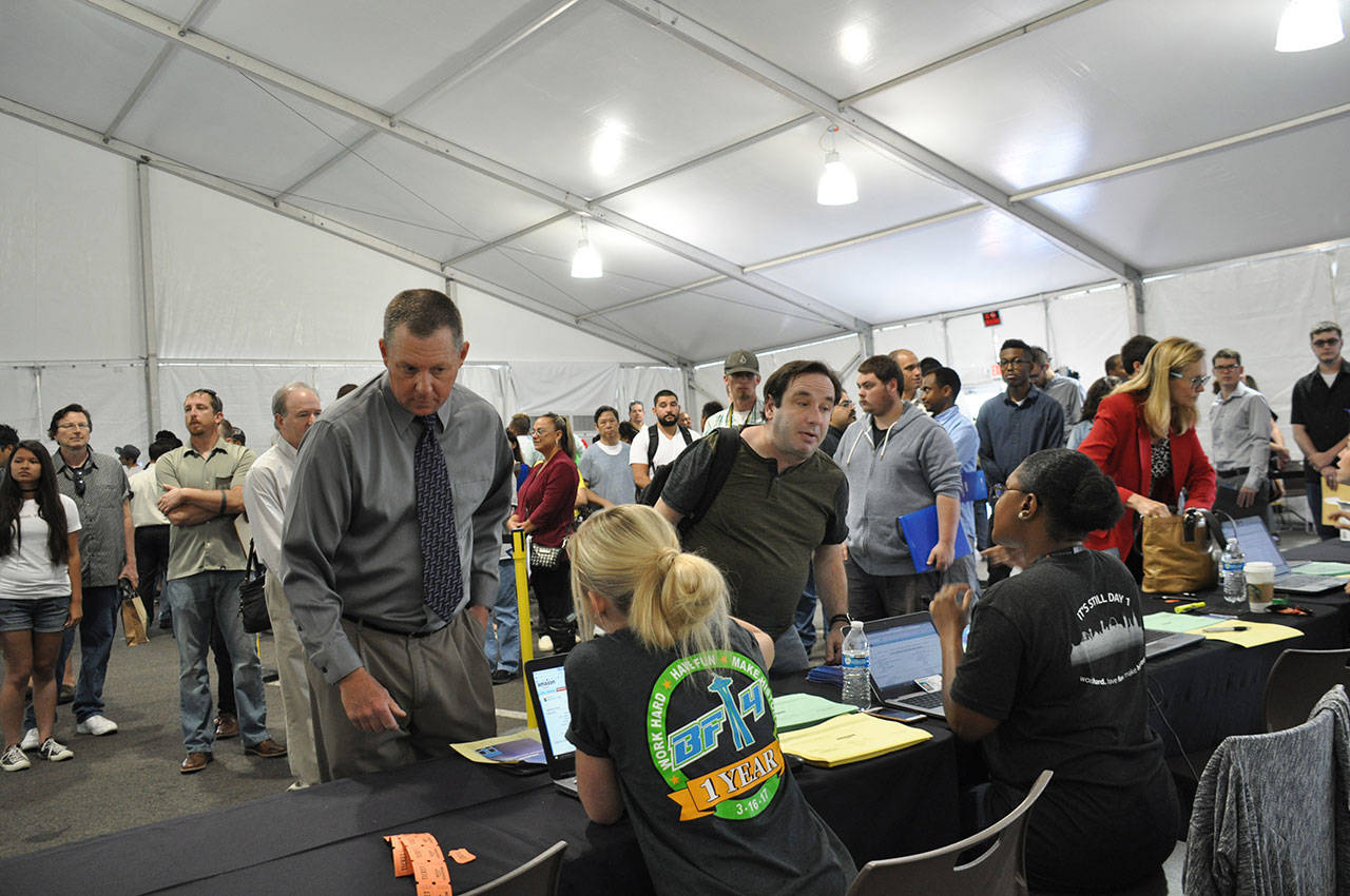 Amazon employees help job seekers check in during Jobs Day on Wednesday at the company’s Kent fulfillment center. HEIDI SANDERS, Kent Reporter