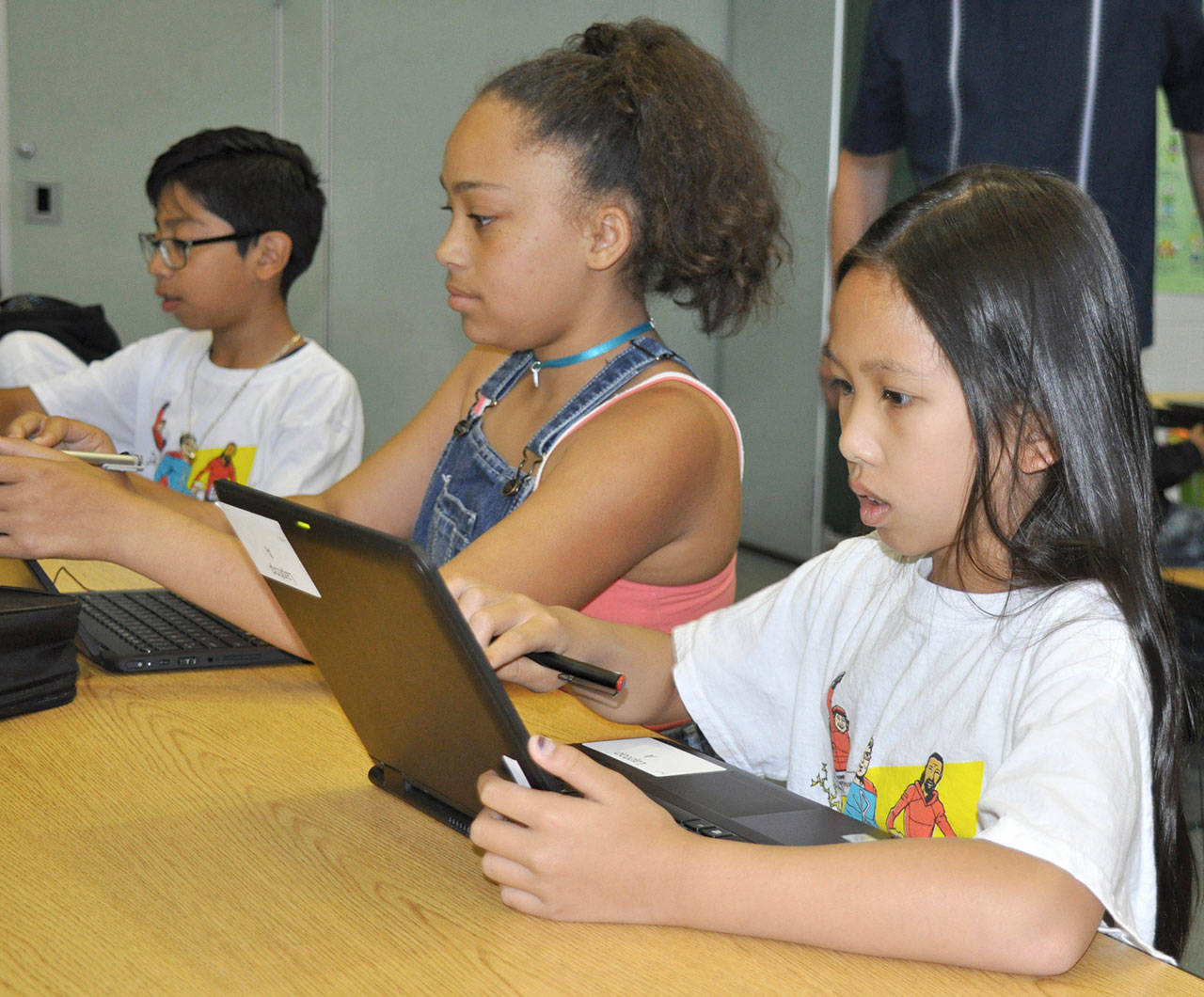 From left, Sebastian Rodriguez, Melanie Learmonth and Voleank Veakrakmann try out laptops during a summer school program at Emerald Park Elementary School. HEIDI SANDERS, Kent Reporter