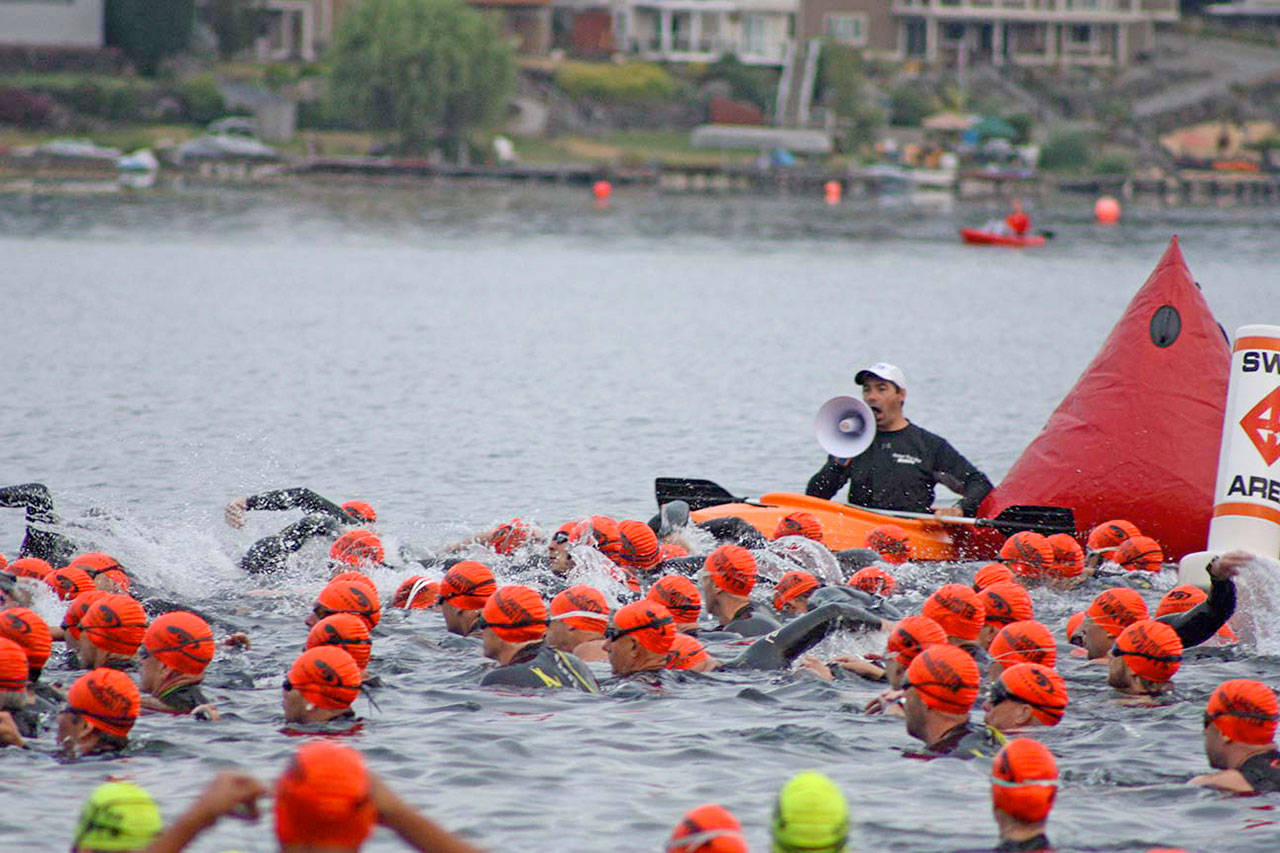 Swimmers in the Olympic division of the Lake Meridian Triathlon start their 1.5-kilometer swim last Saturday morning. More than 520 individuals and more than 20 relay teams competed in the eighth annual event, which includes swimming, biking and running. MARK KLAAS, Kent Reporter