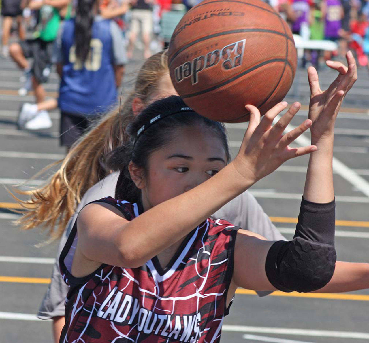 Jade Fajarillo, of the Lady Outlaws of Lynnwood, tries to collect a loose ball during in fifth-grade girls play. MARK KLAAS, Auburn Reporter
