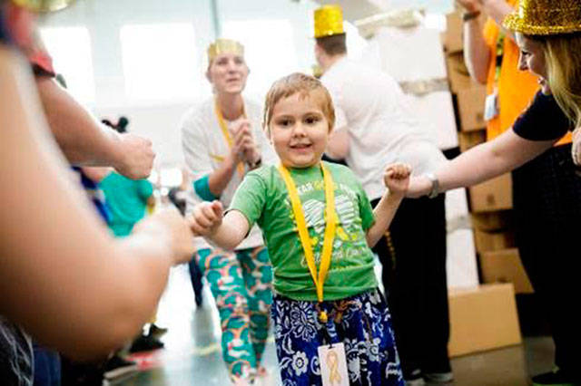 Five-year-old Penny Armstrong of Kent is welcomed by cheering Amazon associates at the fulfillment center. Courtesy Photo/Amazon