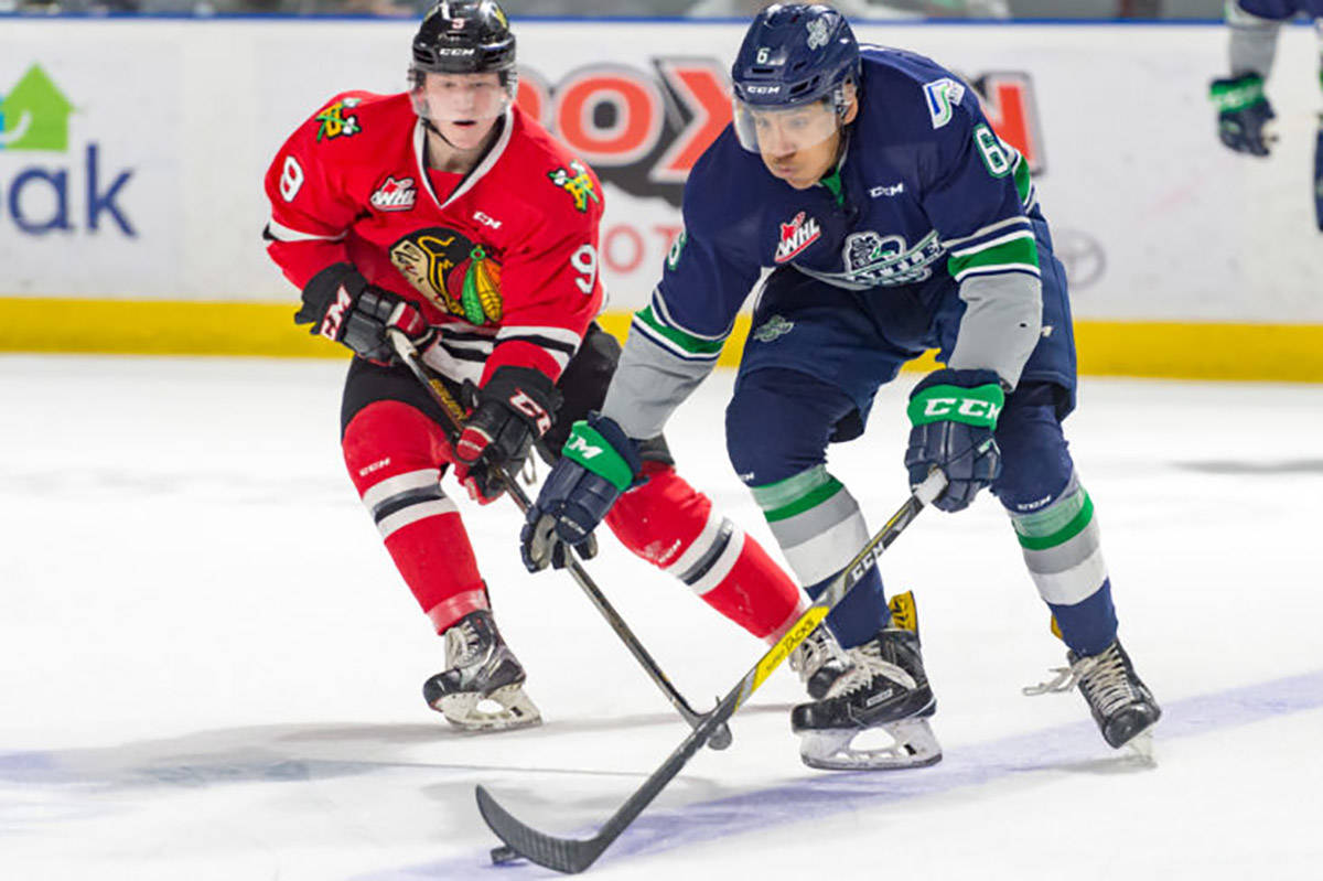 The Thunderbirds’ Aaron Hyman handles the puck as the Winterhawks’ Lane Gilliss pursues during WHL play at the Moda Center on Saturday night. BRIAN LIESSE, T-Birds