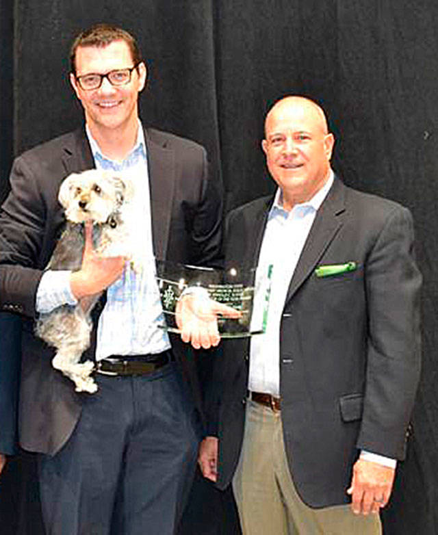 Sen. Joe Fain, with his dog Waffles, joins Greg Hanon, a WSVMA lobbyist, right, to receive his award. COURTESY PHOTO