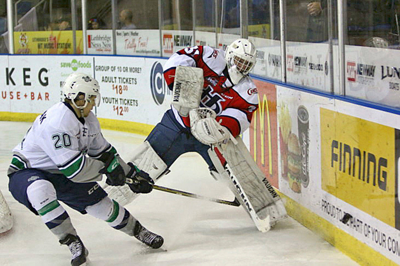The Thunderbirds’ Zack Andrusiak applies pressure as Hurricanes goalie Reece Klassen clears the puck during WHL play Sunday in Lethbridge, Alberta, Canada. Andrusiak had a hat trick in Seattle’s 7-4 win. COURTESY PHOTO, Cindy Adachi