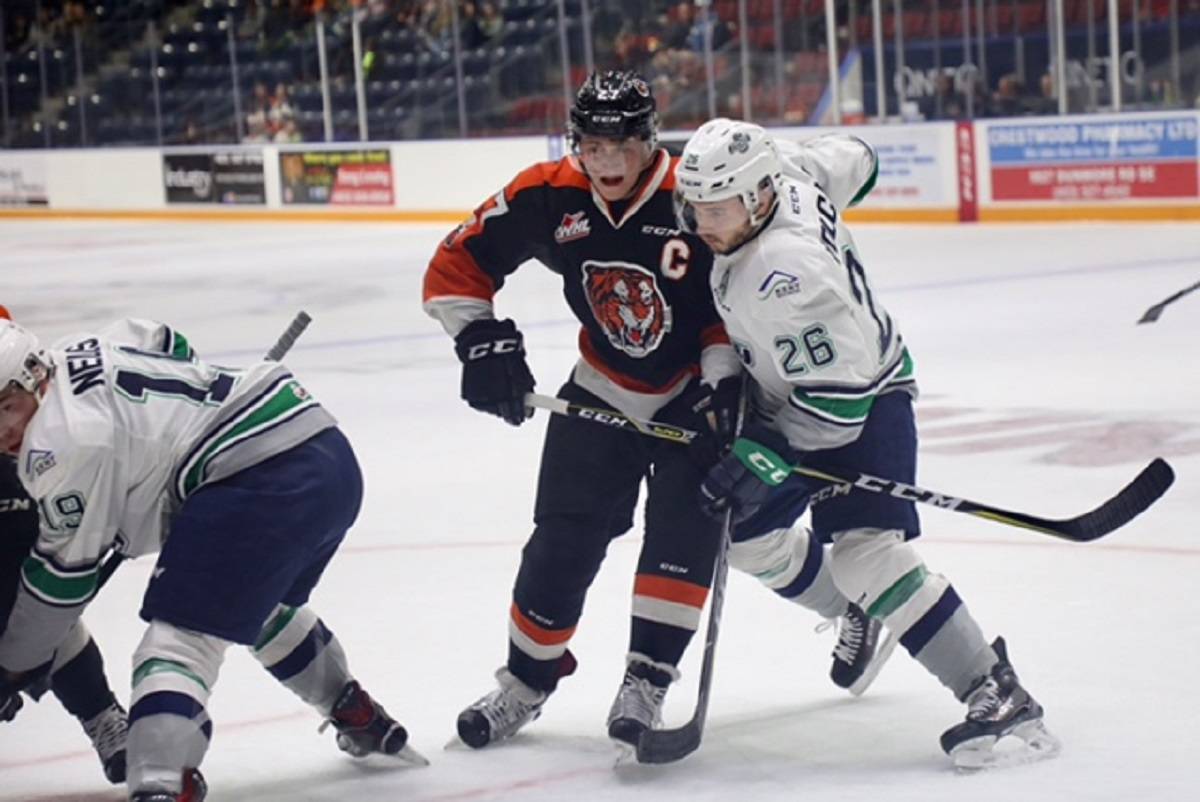 The Thunderbirds’ Nolan Volcan, right, and the Tigers’ Mark Rassell battle for position during WHL play Saturday. COURTESY PHOTO, Randy Feere