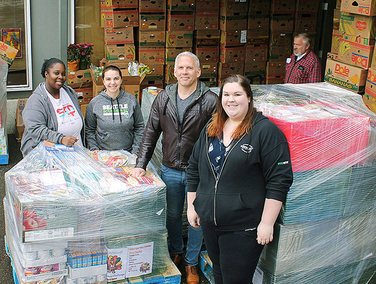 Camico Rivon, assistant director of Kent Food Bank, Jeniece Choate, executive director of Kent Food Bank, Torklift Central owner Jack Kay and Torklift Central employee Kerstin Stokes look on as goods are delivered for Thanksgiving to the Kent Food Bank. COURTESY PHOTO, Torklift Central