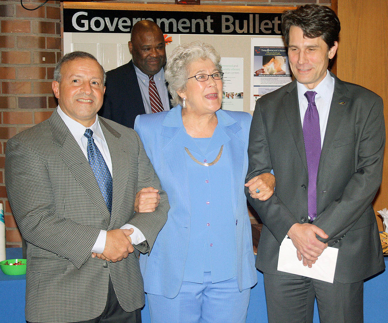 Kent Mayor Suzette Cooke recognizes outgoing City Council members Jim Berrios, left, and Dennis Higgins, right, as Council President Bill Boyce looks on from the background. STEVE HUNTER, Kent Reporter