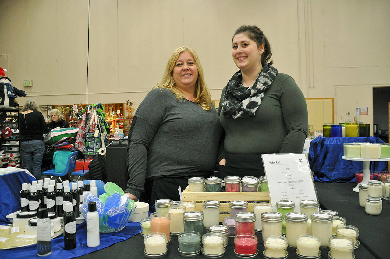 Rita Kay Ajeto, left, and her daughter, Sheil Dodge, owners of Fat Cat Soaps and More, display their handmade candles and soaps during the annual Holiday Bazaar last year at Kent Commons. FILE PHOTO, Kent Reporter