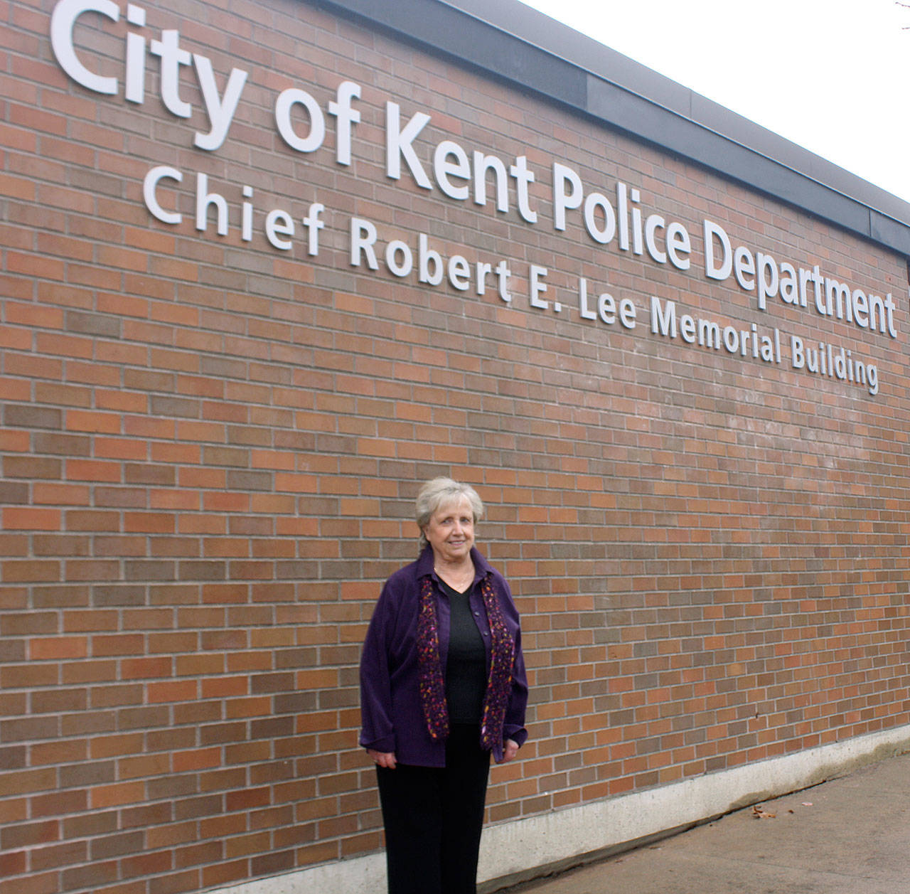 Vicki (Lee) Schmitz, stands under the new name of police headquarters in Kent with Chief added in front of Robert E. Lee. STEVE HUNTER, Kent Reporter